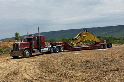 Truck Hauling Excavator