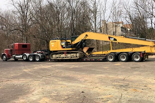 Truck Hauling CAT Excavator