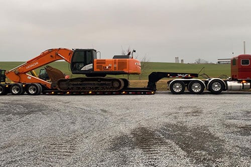 Truck Hauling Excavators